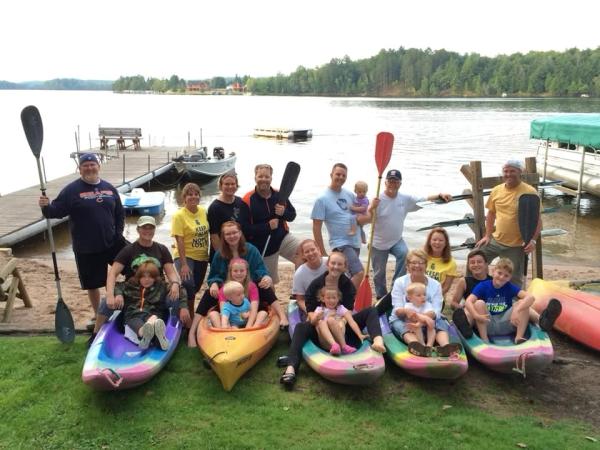 large family posing for a photo in kayaks